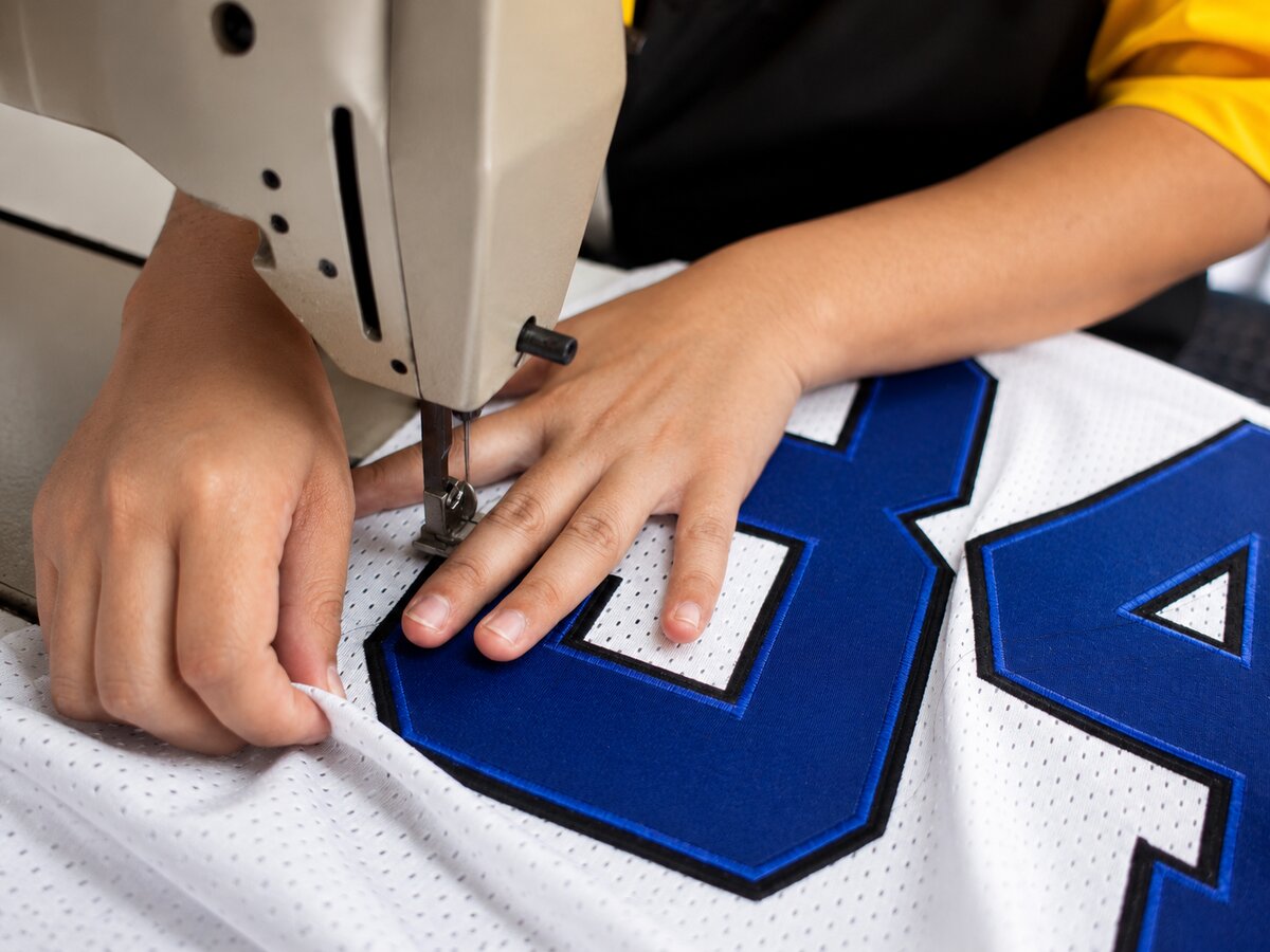 Hands at the sewing machine in the Allen Sportswear shop